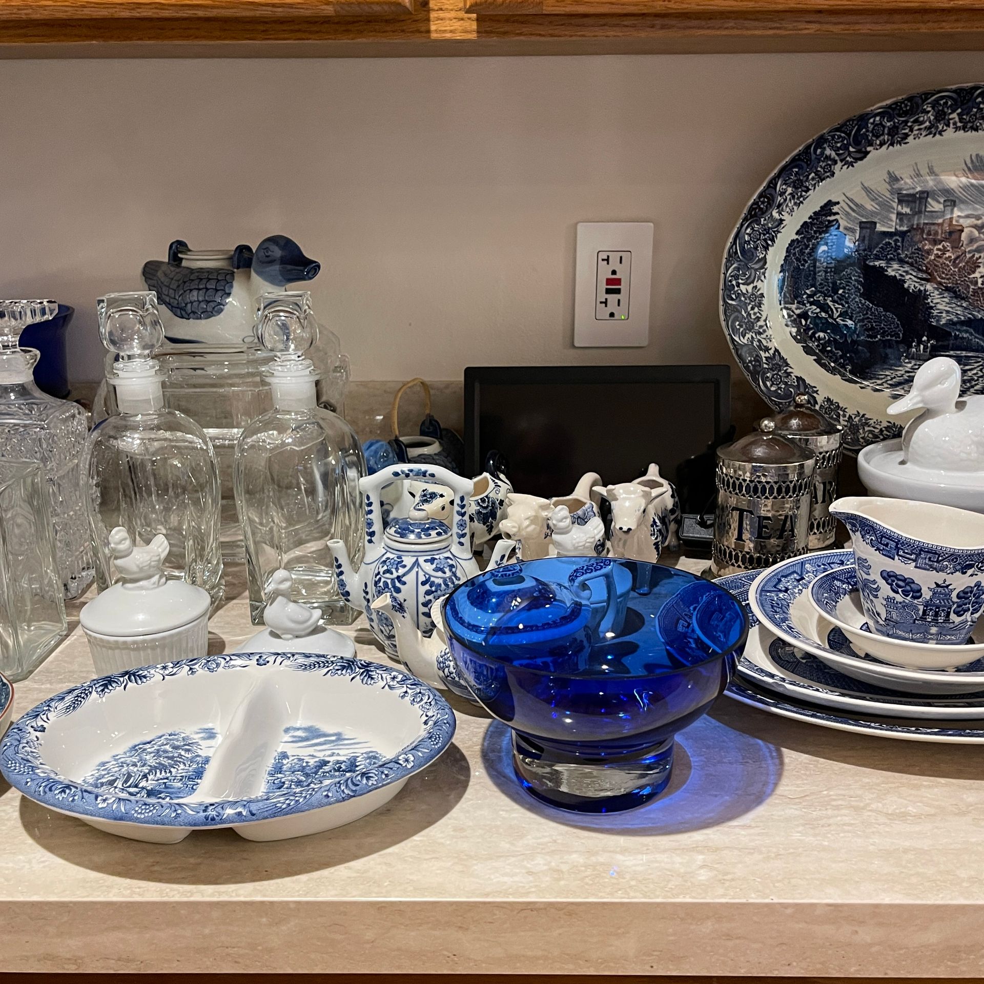 Various blue and white decorative items on a shelf, including dishes, glasses, and a blue glass bowl.