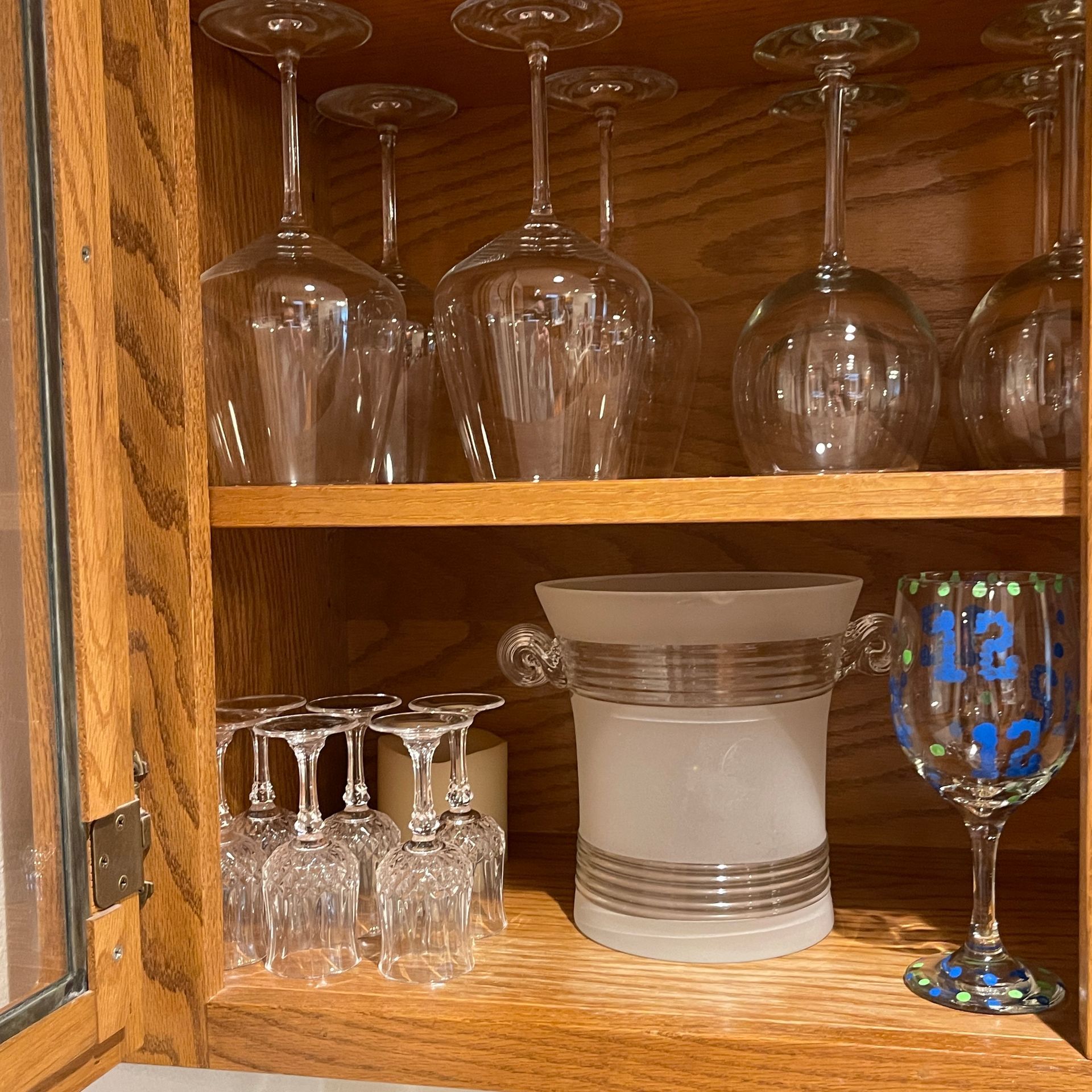 Wooden cabinet with various wine glasses on display.