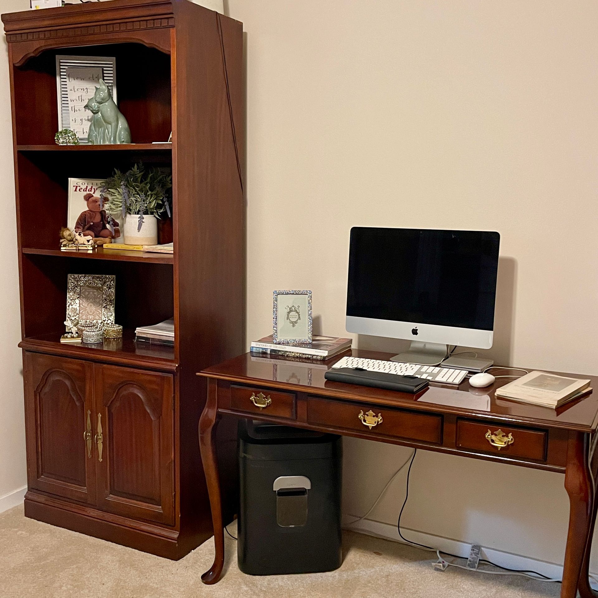 Wooden desk with a computer and bookshelf in a home office setting.