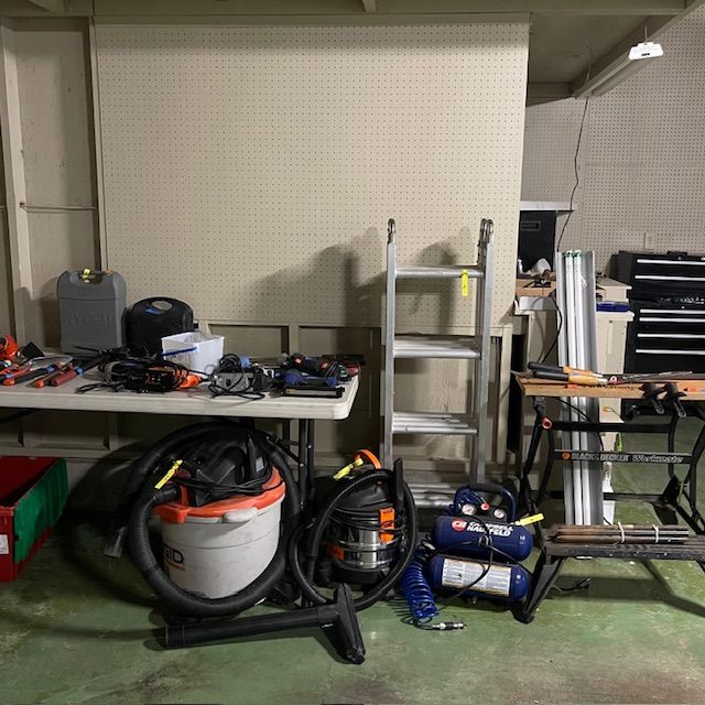 Workshop scene with tools, a ladder, and a workbench.
