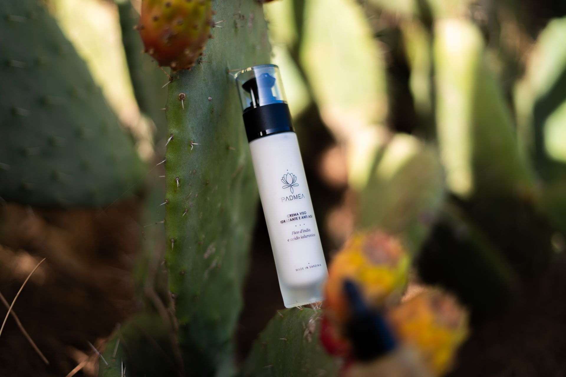 Una donna sorride mentre tiene in mano una piccola bottiglia di lozione.