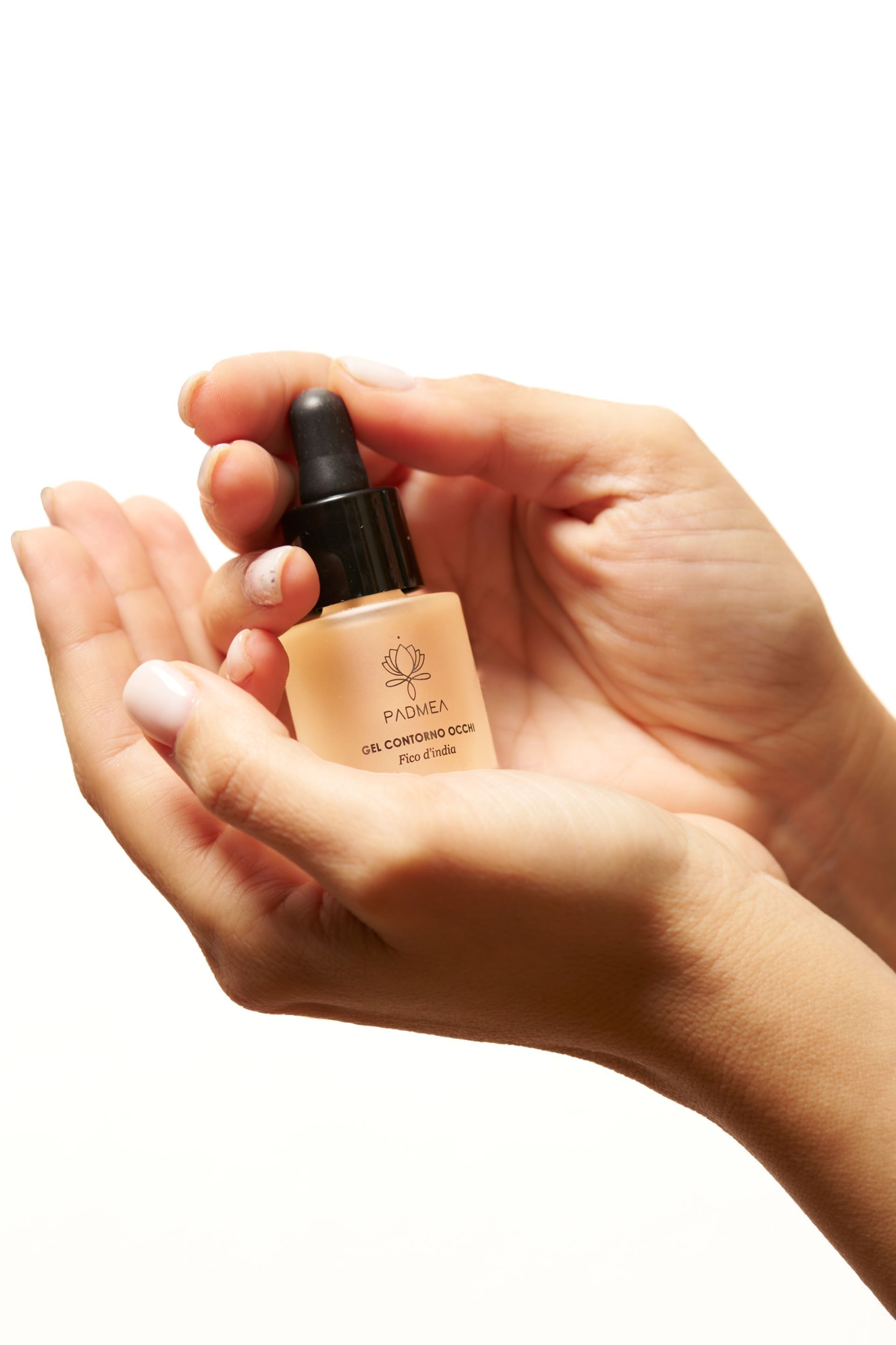 Una donna tiene in mano una piccola bottiglia di liquido.