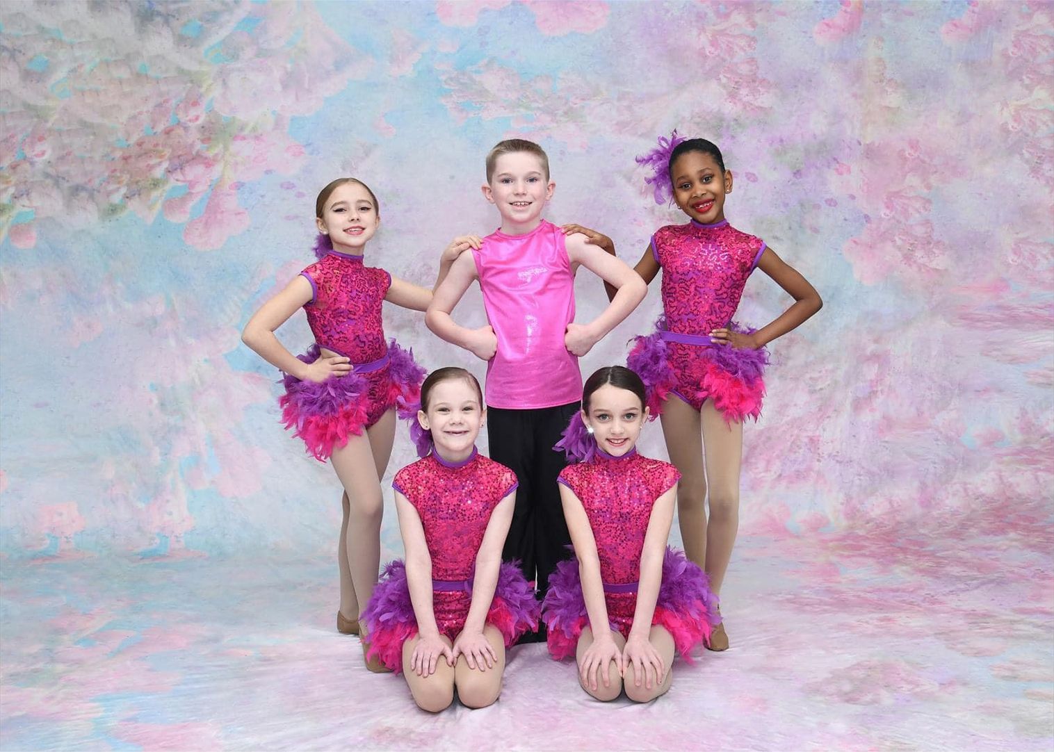 A group of young dancers are posing for a picture.