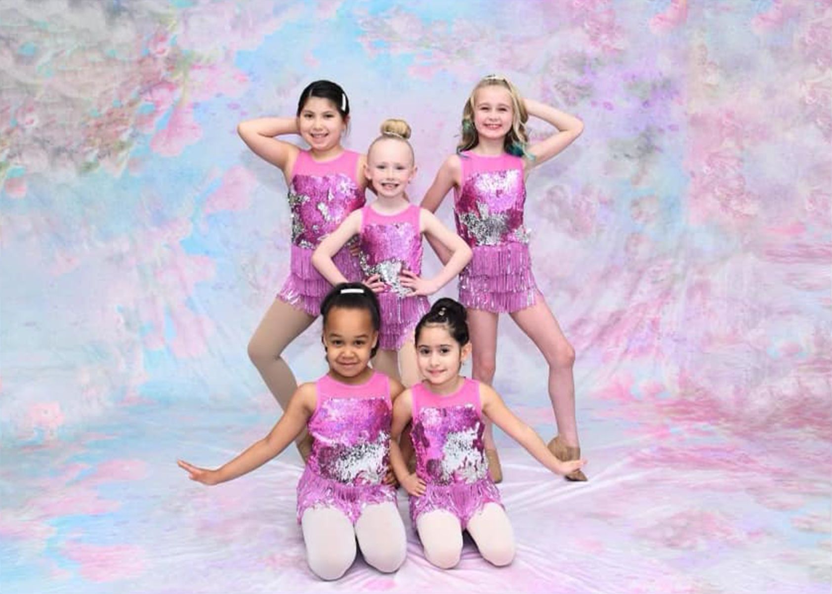 A group of young girls are posing for a picture.
