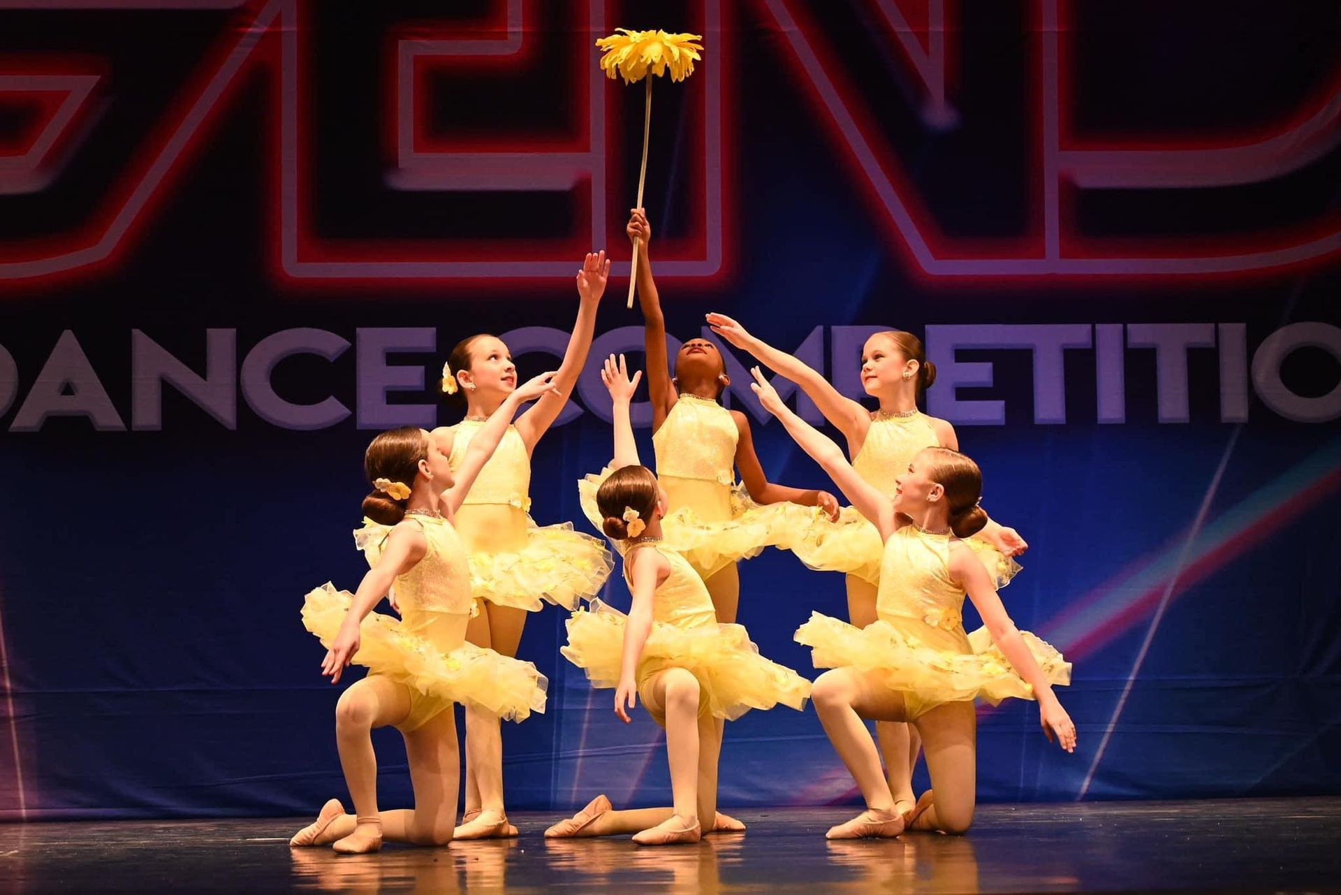 A group of young girls are dancing on a stage.