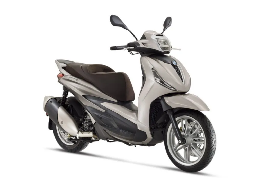 Scooter Piaggio Beverly beige con sella scura, parcheggiato su sfondo bianco.