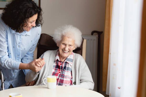 caregiver assisting elderly woman with early stage alzheimer's disease