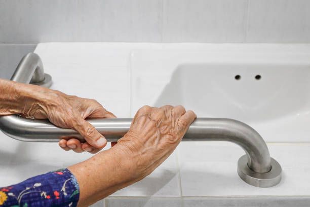 woman with dementia afraid to bathe or shower holding on to grab bar and not budging.
