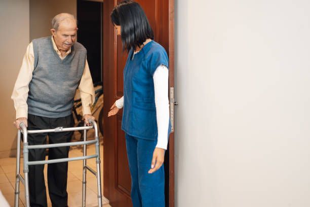 home health aide providing stand-by walking assistance for elderly at home