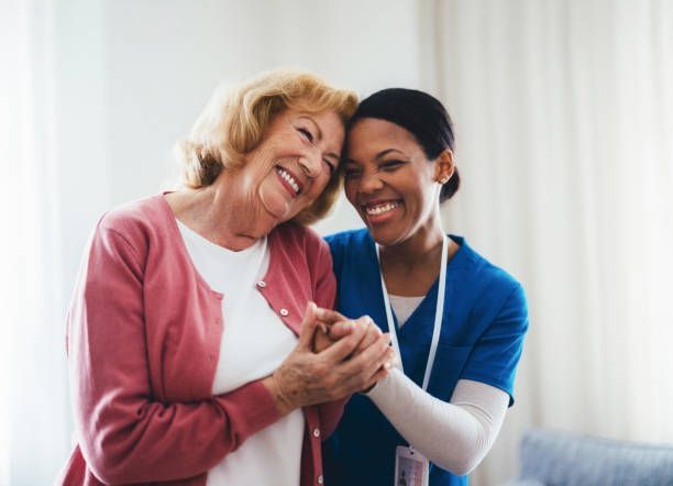Senior woman with dementia receiving compassionate home care assistance from a caregiver in a NYC