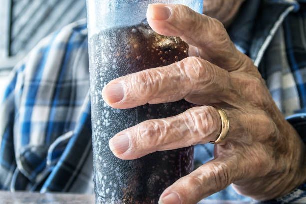 elderly man drinking cola soda loaded with added sugar