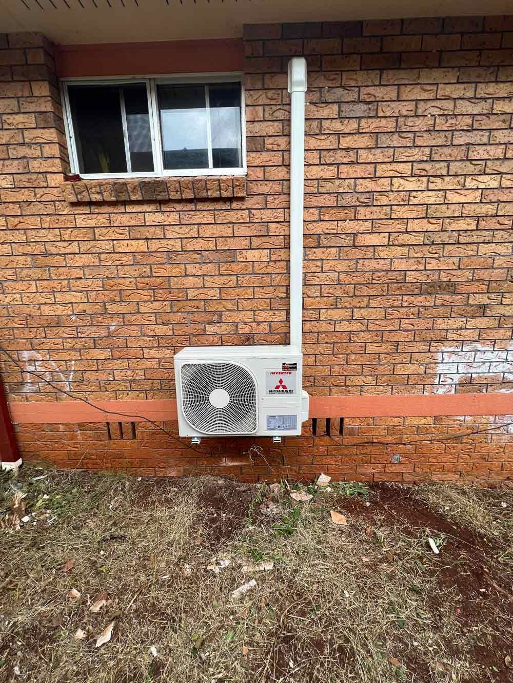 A Compressor Hanging on the Brick Wall — Electrician in Inverell, NSW