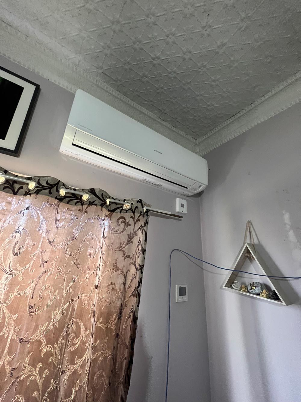 A Split Type Air-Conditioner in a Bedroom — Electrician in Laurieton, NSW