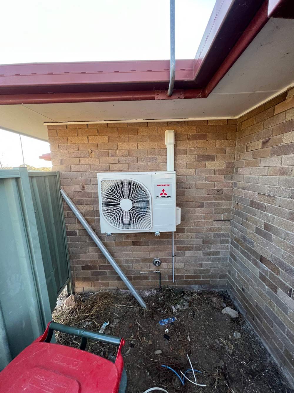 An Outdoor Compressor Hanging on the Wall — Electrician in Armidale, NSW