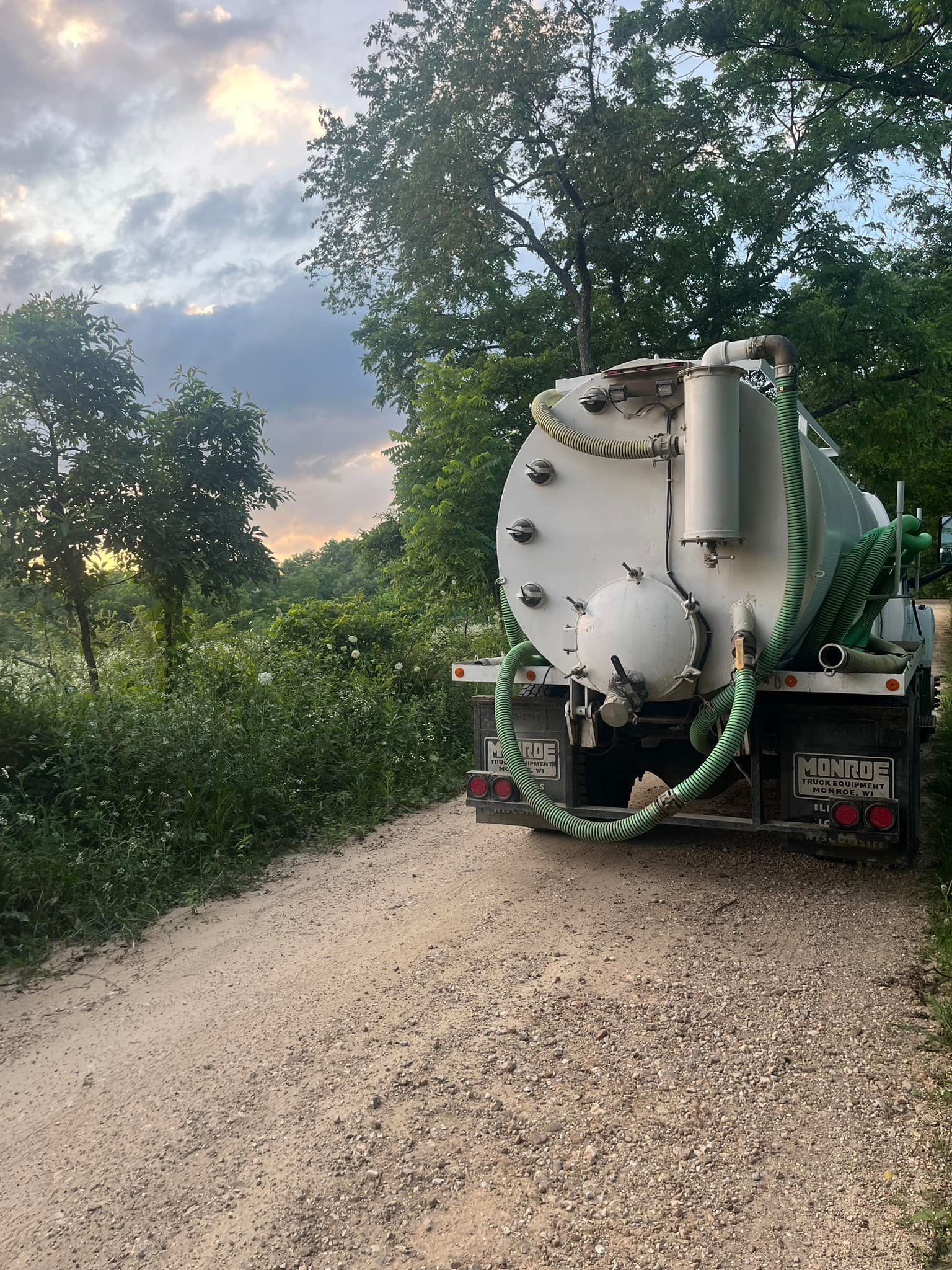 Moore Septic Services septic truck driving away on gravel road | Mountain Grove MO