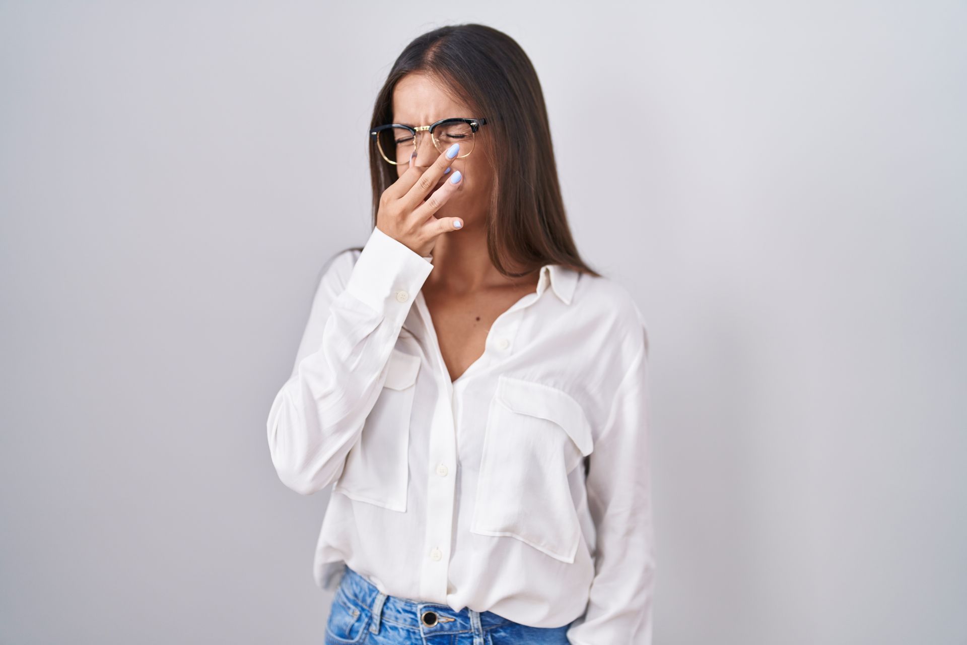 Woman in white shirt holding nose because of a stinky smell | Houston MO