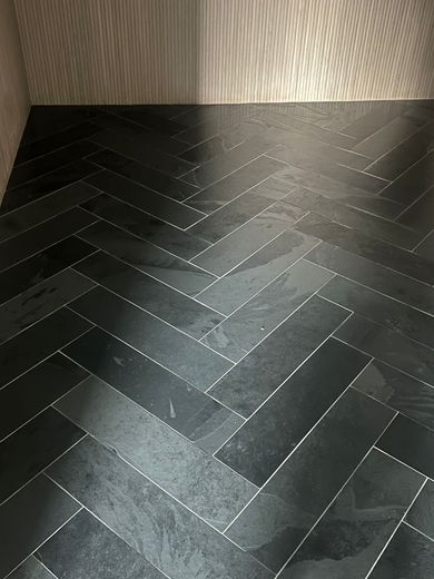 Herringbone pattern of dark slate tiles on floor.