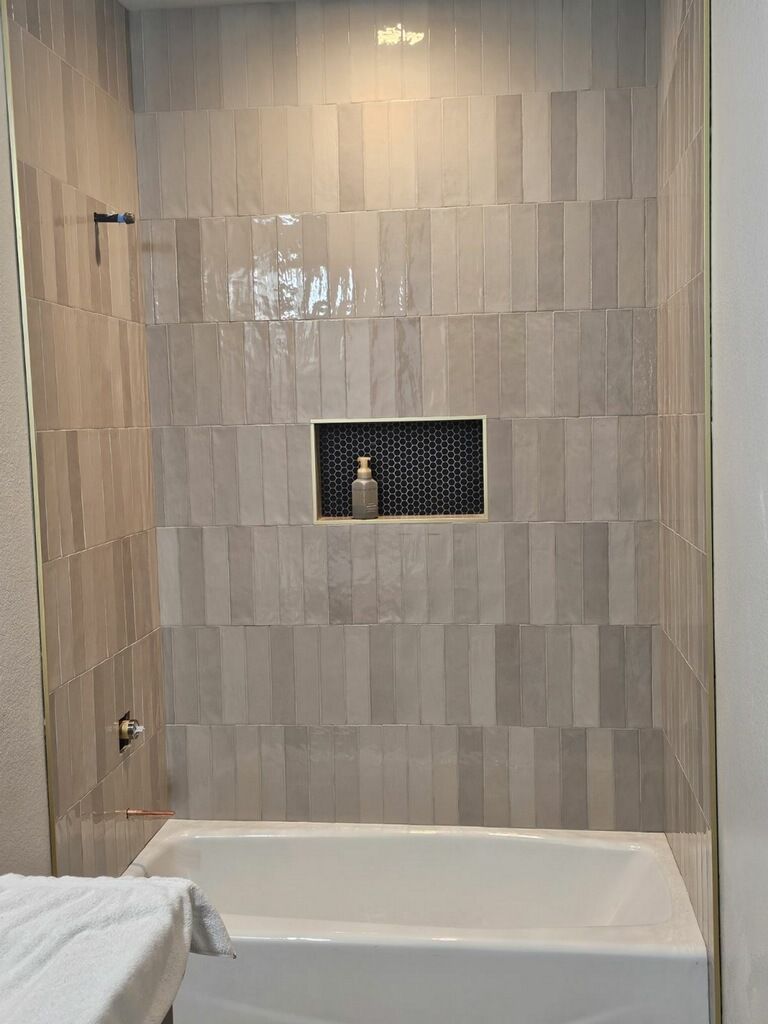 Bathroom with marble floors and walls, a shower, vanity, and toilet.