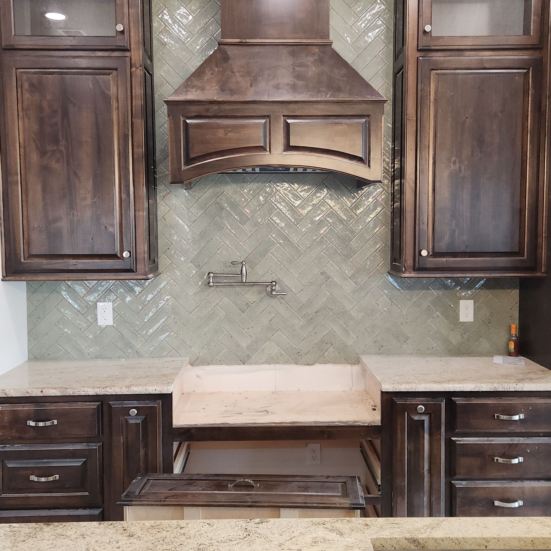 Modern bathroom with a glass shower, dark hexagon tile floor, and a doorway to another room.