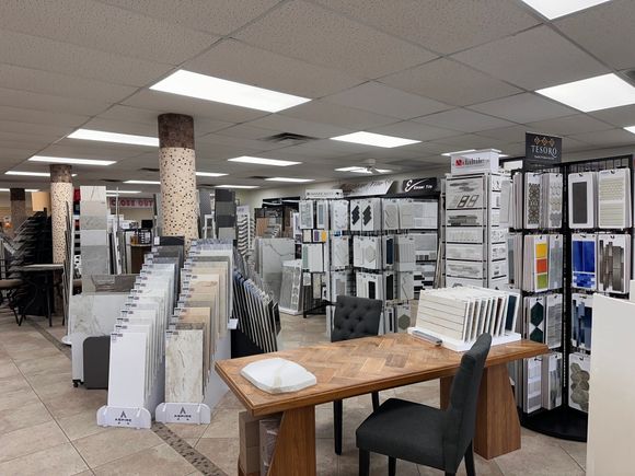 Tile showroom with displays of tile samples and a wooden table.