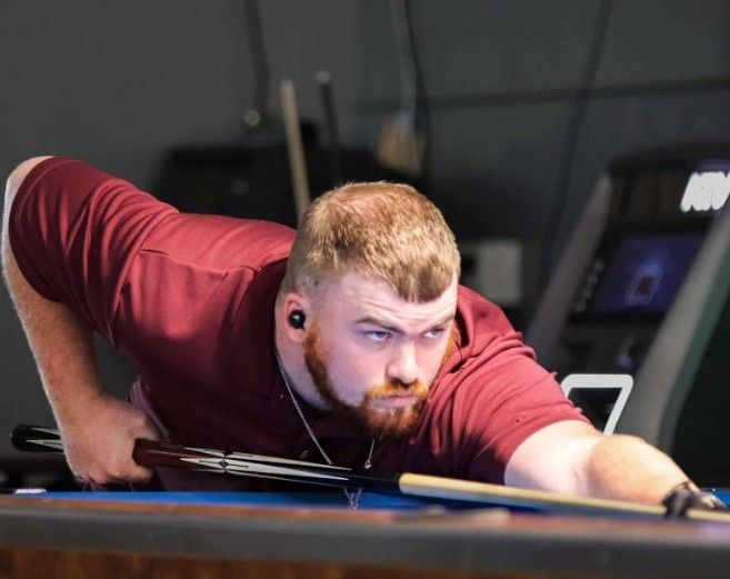 Family selfie in front of waterfall; woman in sunglasses, boy in red, man in hat.