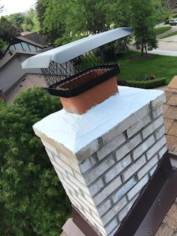 Chimney with a black mesh cap and a white painted top section, viewed from above.