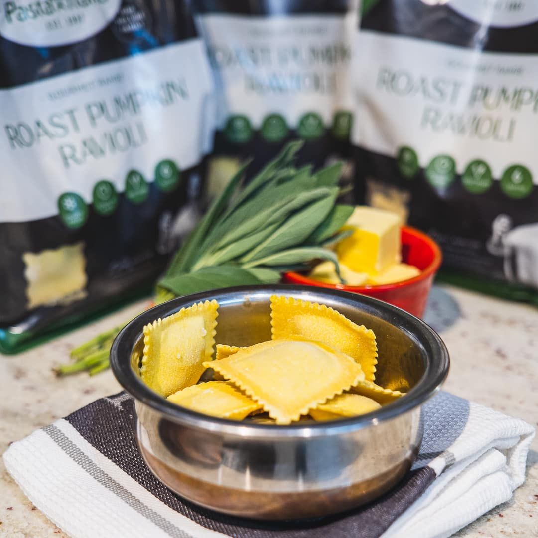 a bowl of ravioli next to a bag of roast pumpkin ravioli