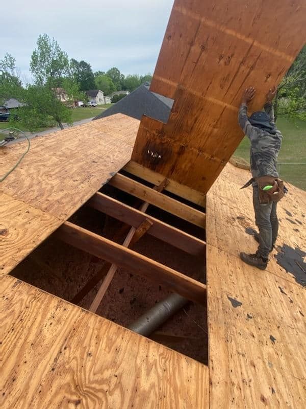 Man Holding A Piece Of Plywood — Enterprise, AL — Waters Roofing LLC