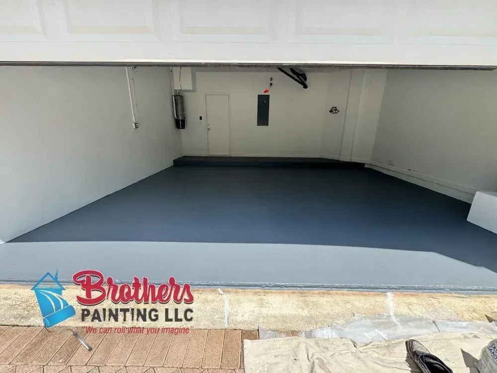 Empty garage with freshly painted blue-gray floor and white walls