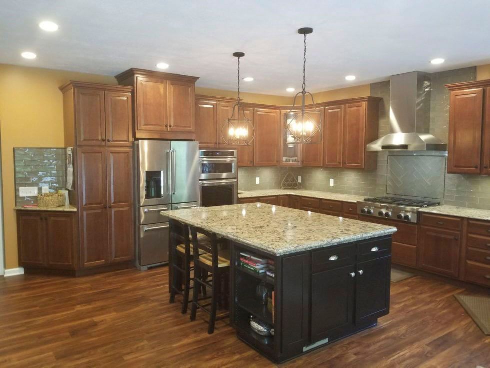 A kitchen with wooden cabinets, granite countertops, stainless steel appliances, and a large island.