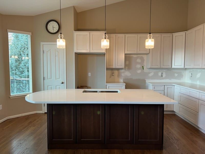 A kitchen with white cabinets and a large island.