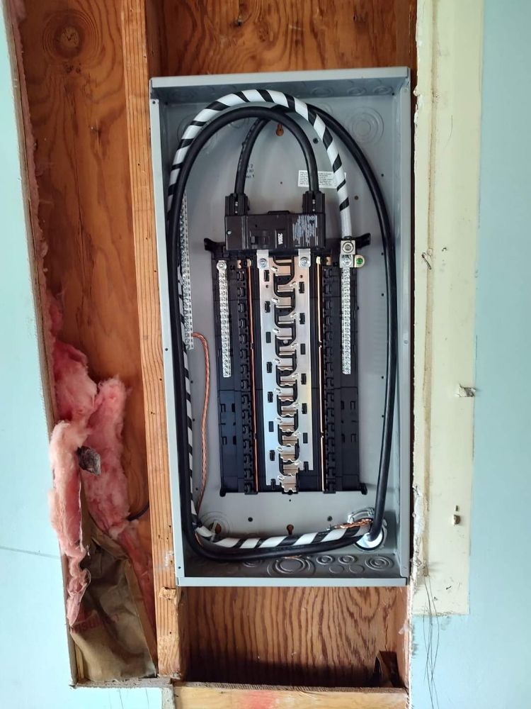 A electrical box is hanging on a wooden wall.