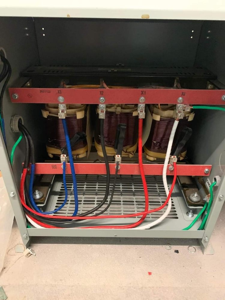 The inside of a transformer with a lot of wires coming out of it.
