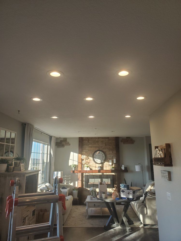 A living room with a lot of lights on the ceiling and a ladder.