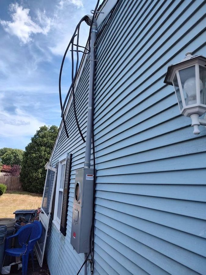 A blue house with a ladder attached to the side of it.