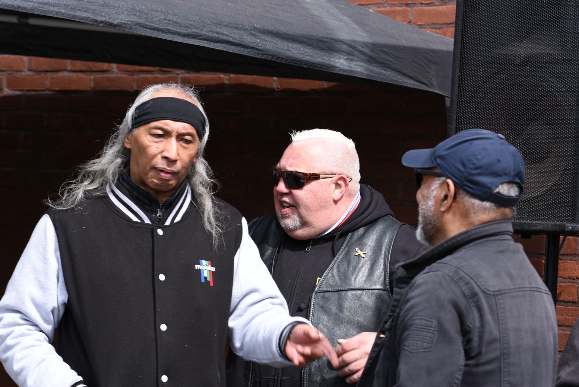 Een groep mannen staat naast elkaar en praat.