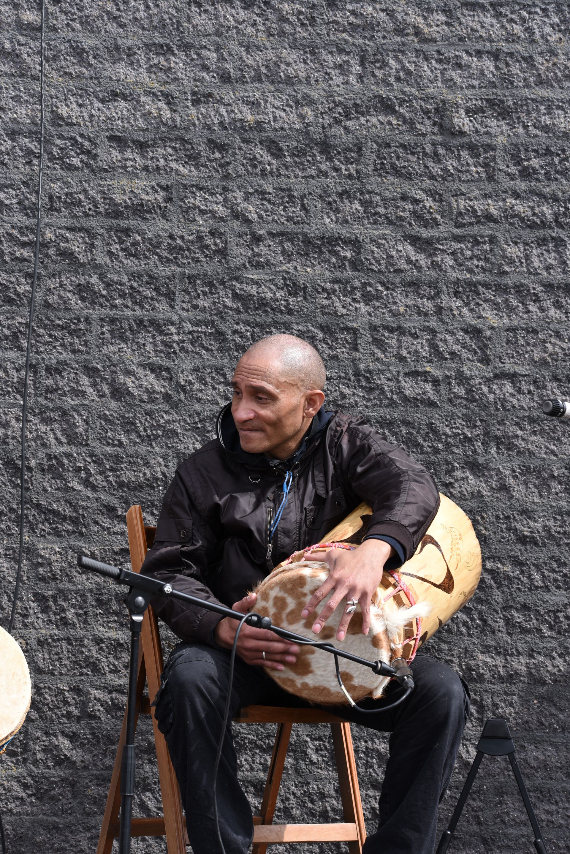 Een man zit in een stoel en speelt een trommel.