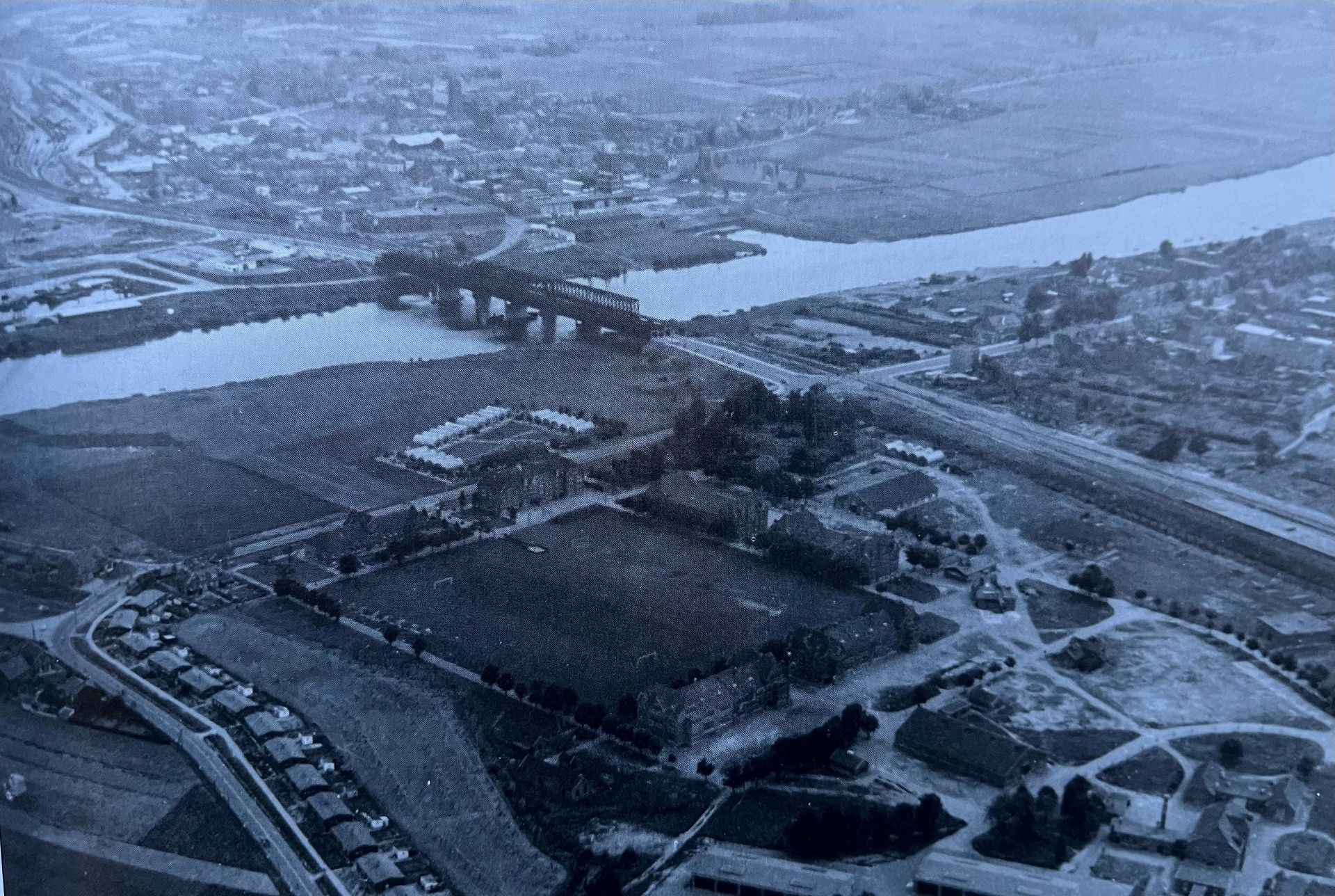 Een luchtfoto van een stad met een brug en een rivier