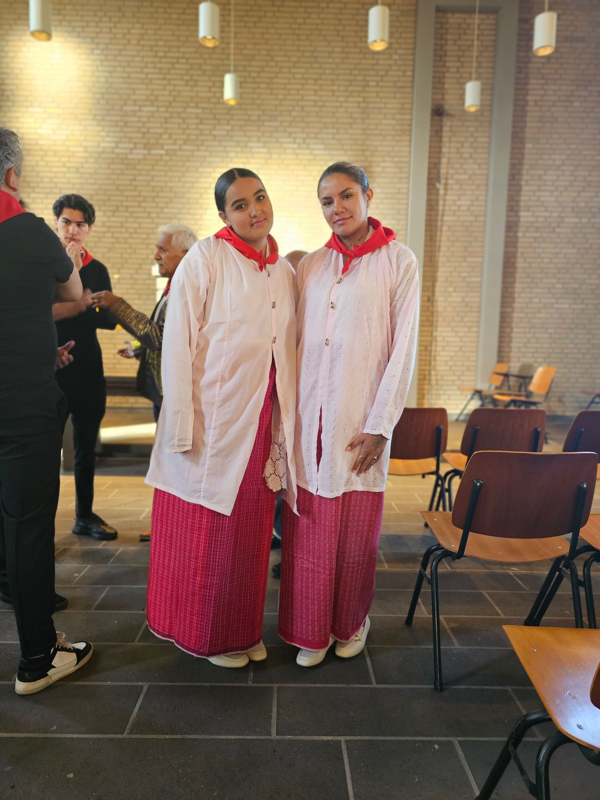 Twee vrouwen staan ​​naast elkaar in een kamer met stoelen