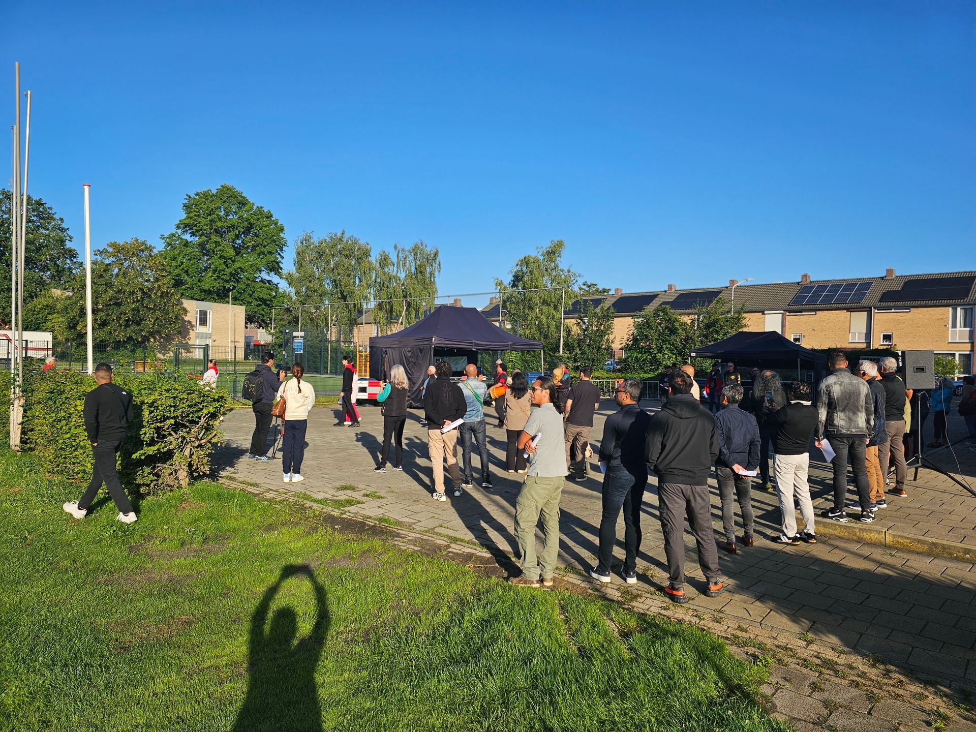 Een groep mensen staat in een grasveld.