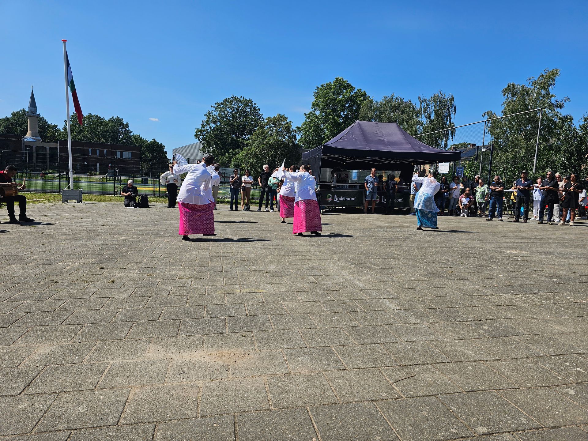 Een groep mensen danst op een bakstenen stoep