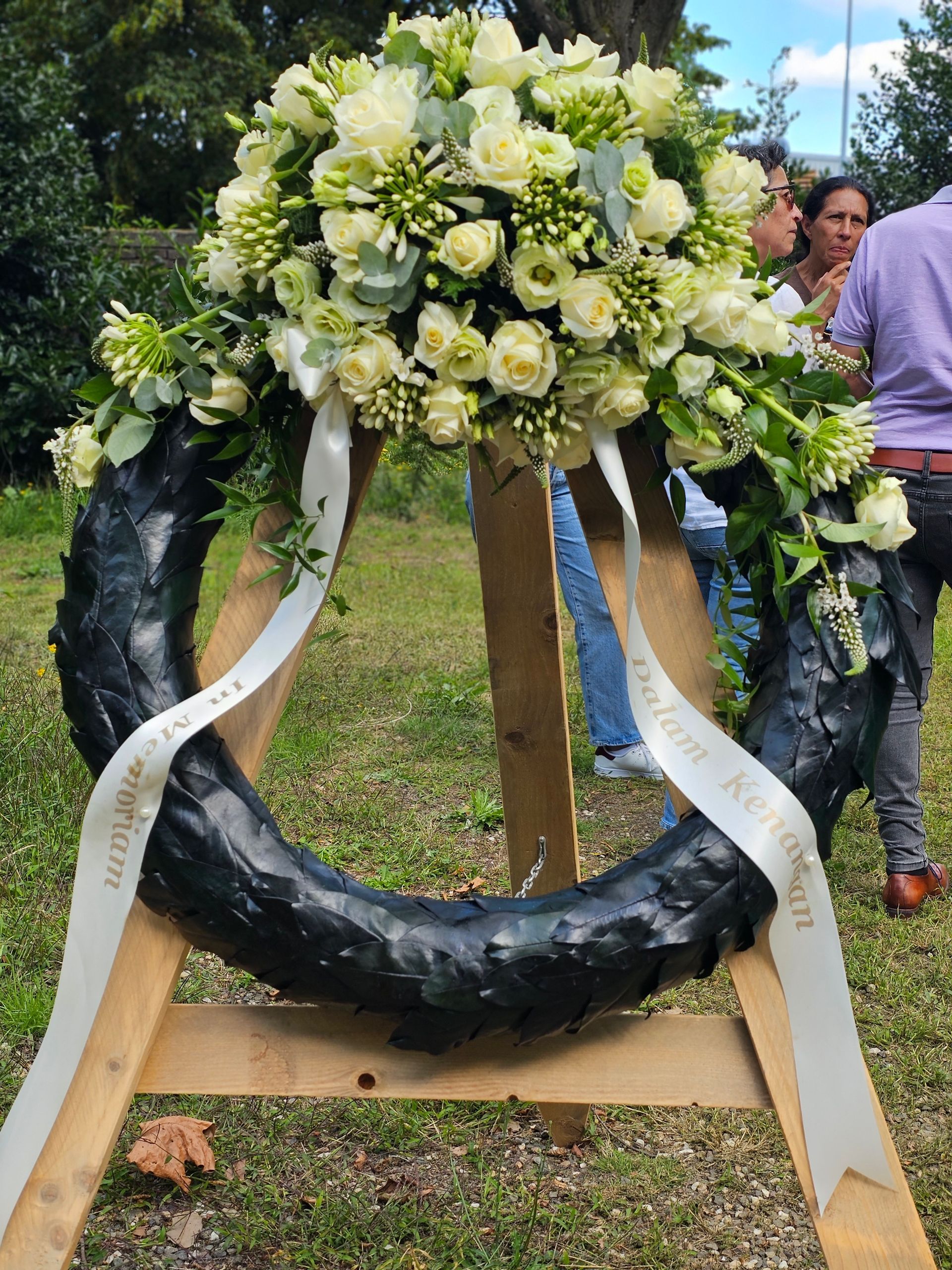 Op een houten standaard staat een krans gemaakt van een autoband