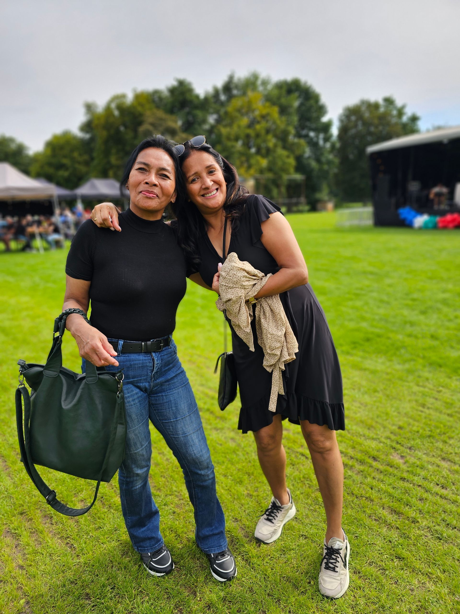 Twee vrouwen poseren voor een foto in een grasveld.