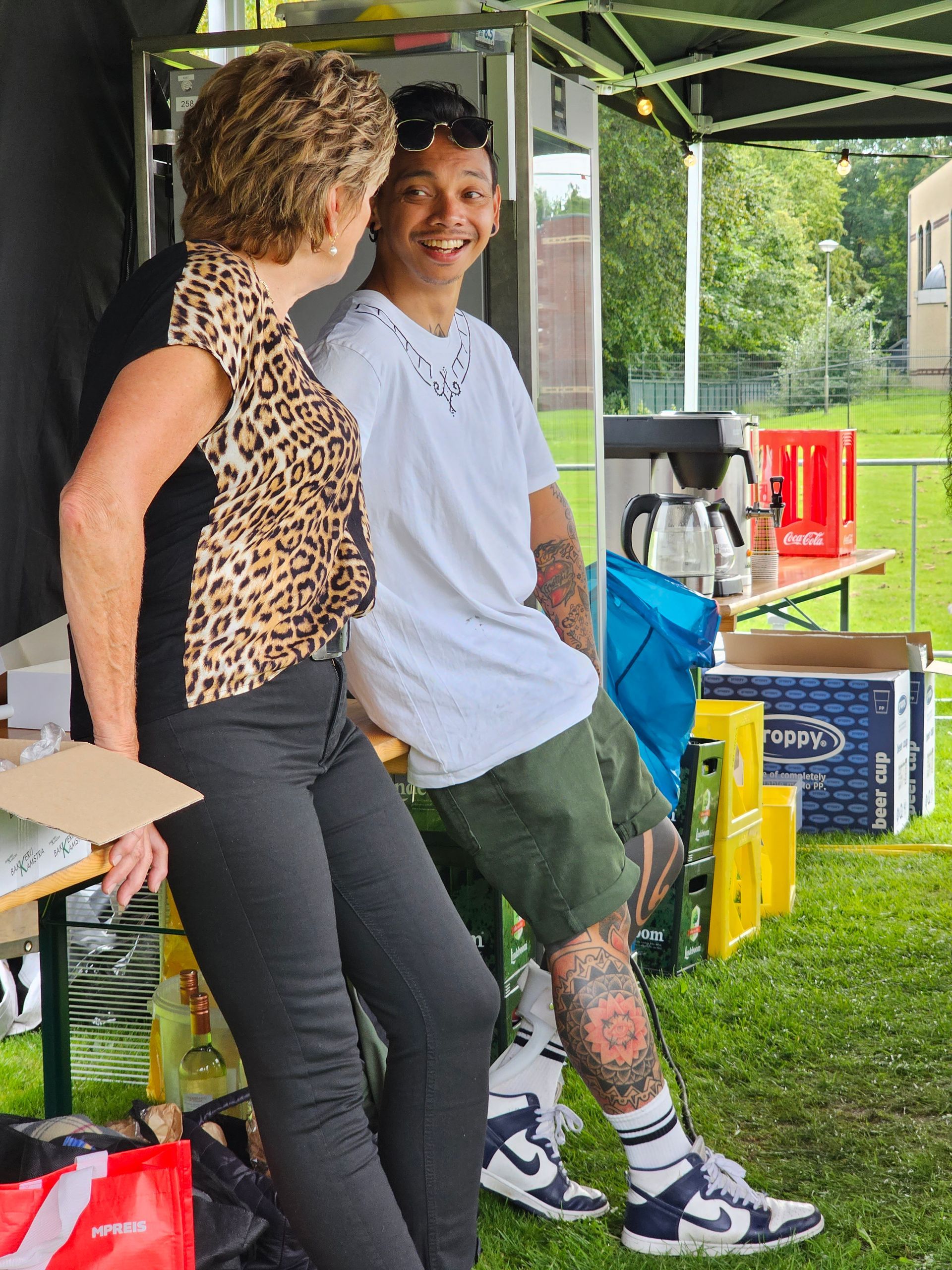 Een man en een vrouw zitten onder een tent met elkaar te praten.