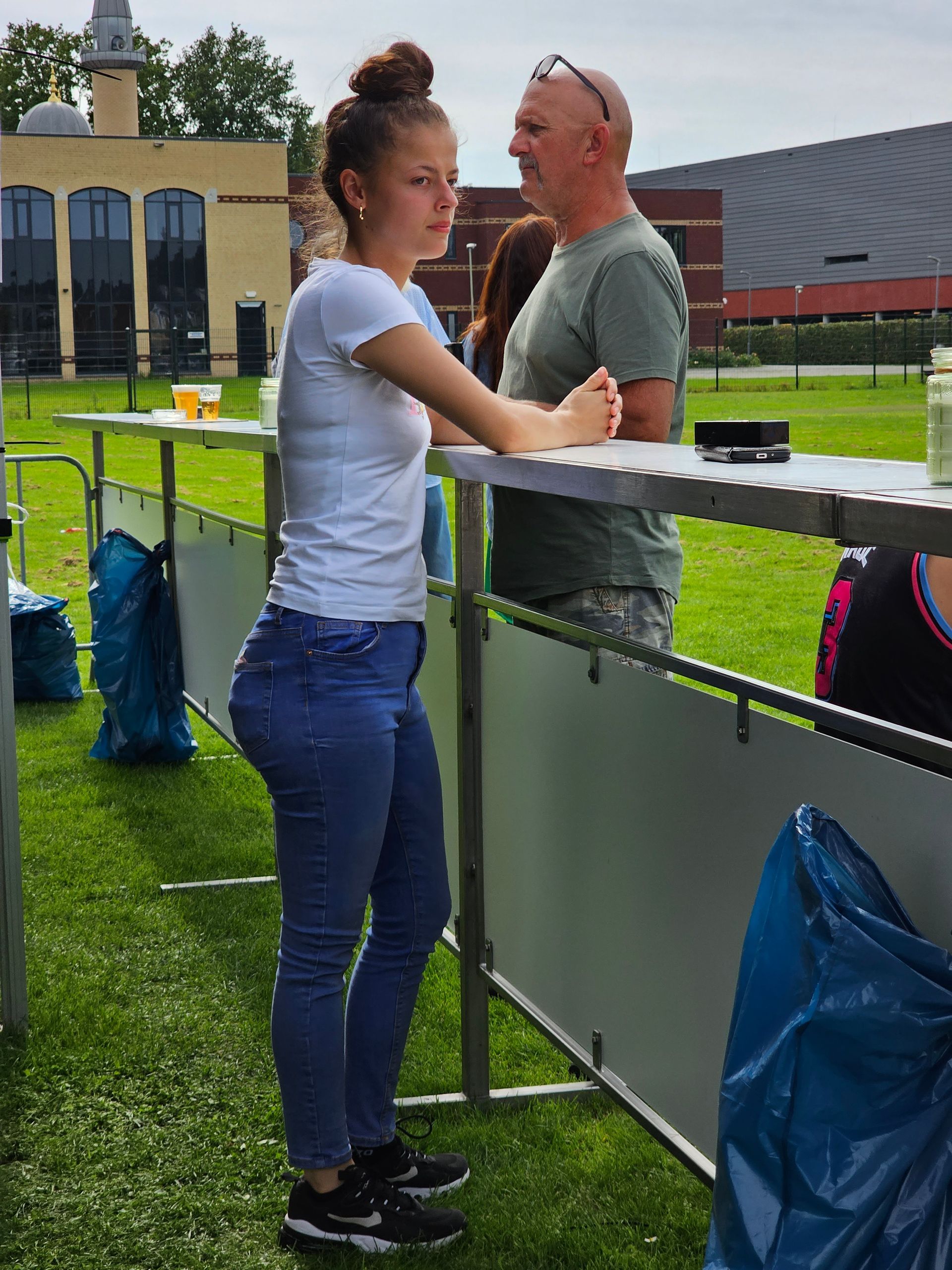 Een man en een vrouw staan ​​achter een hek met elkaar te praten