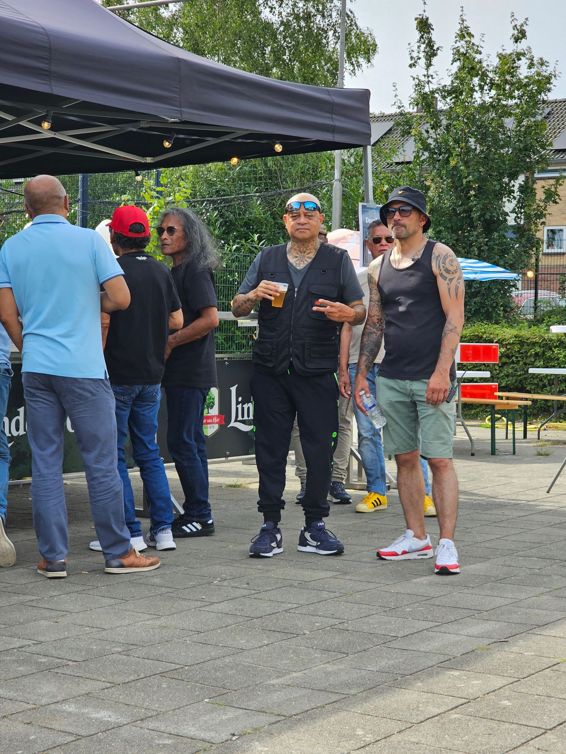 Een groep mannen staat voor een tent.