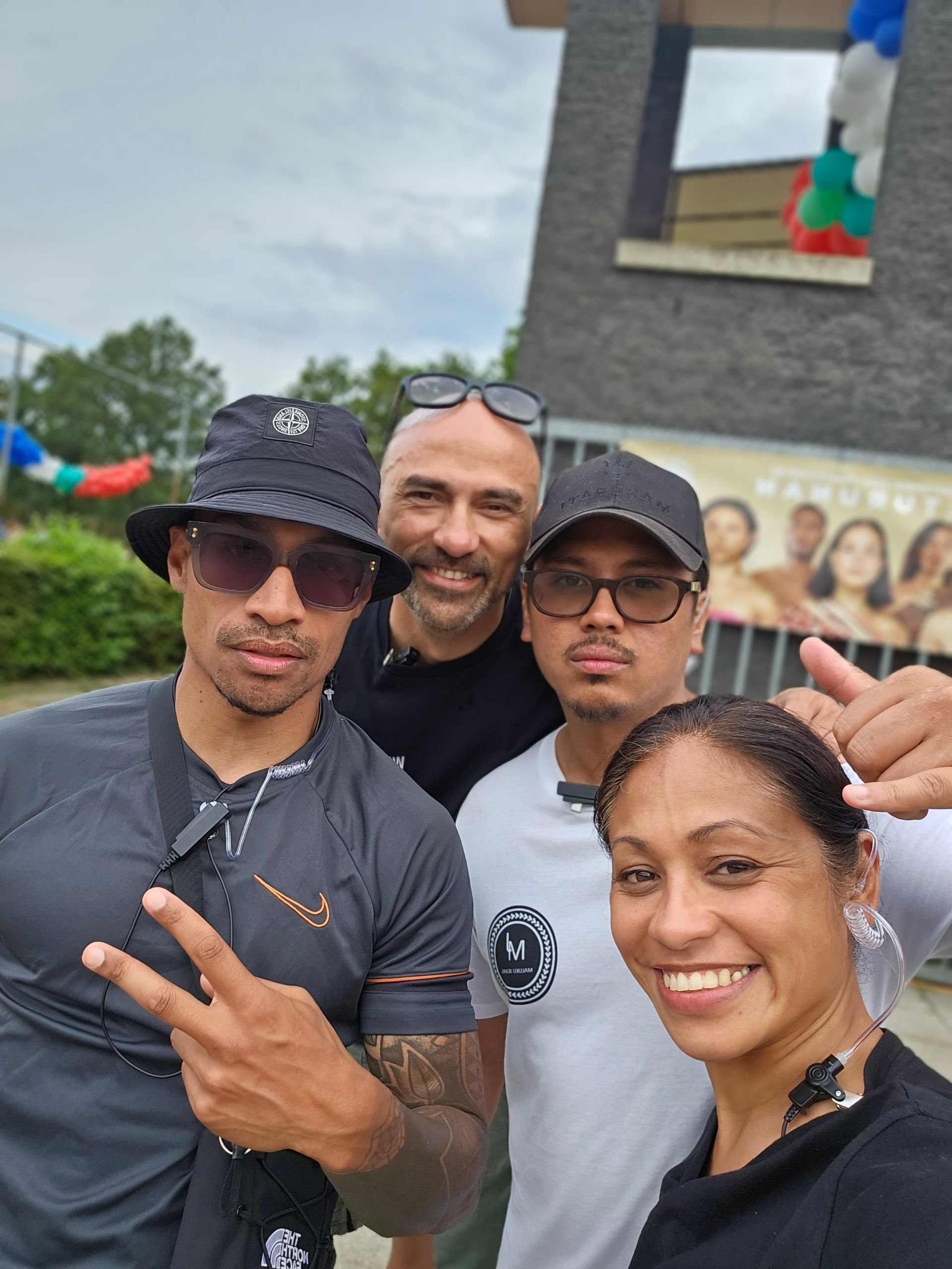 Een groep mensen poseert voor een foto voor een gebouw.