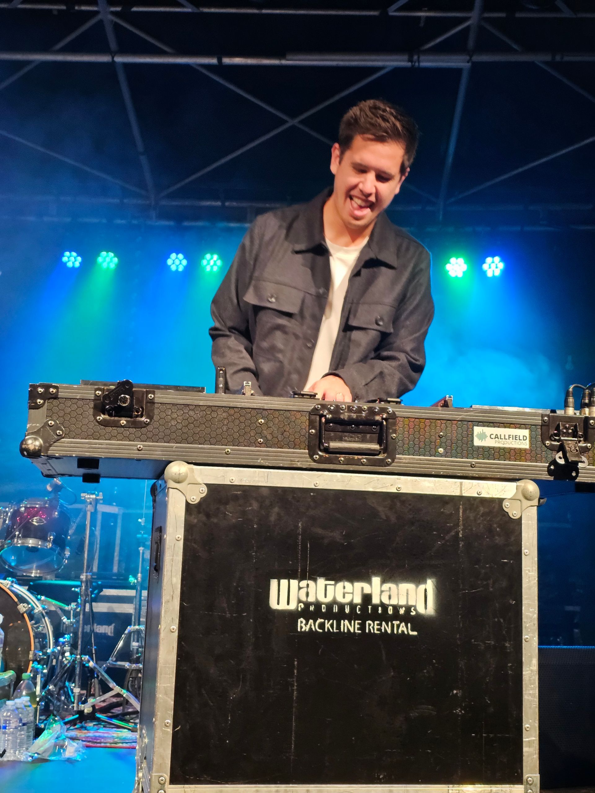 Een man die voor een koffer staat met de tekst weberland