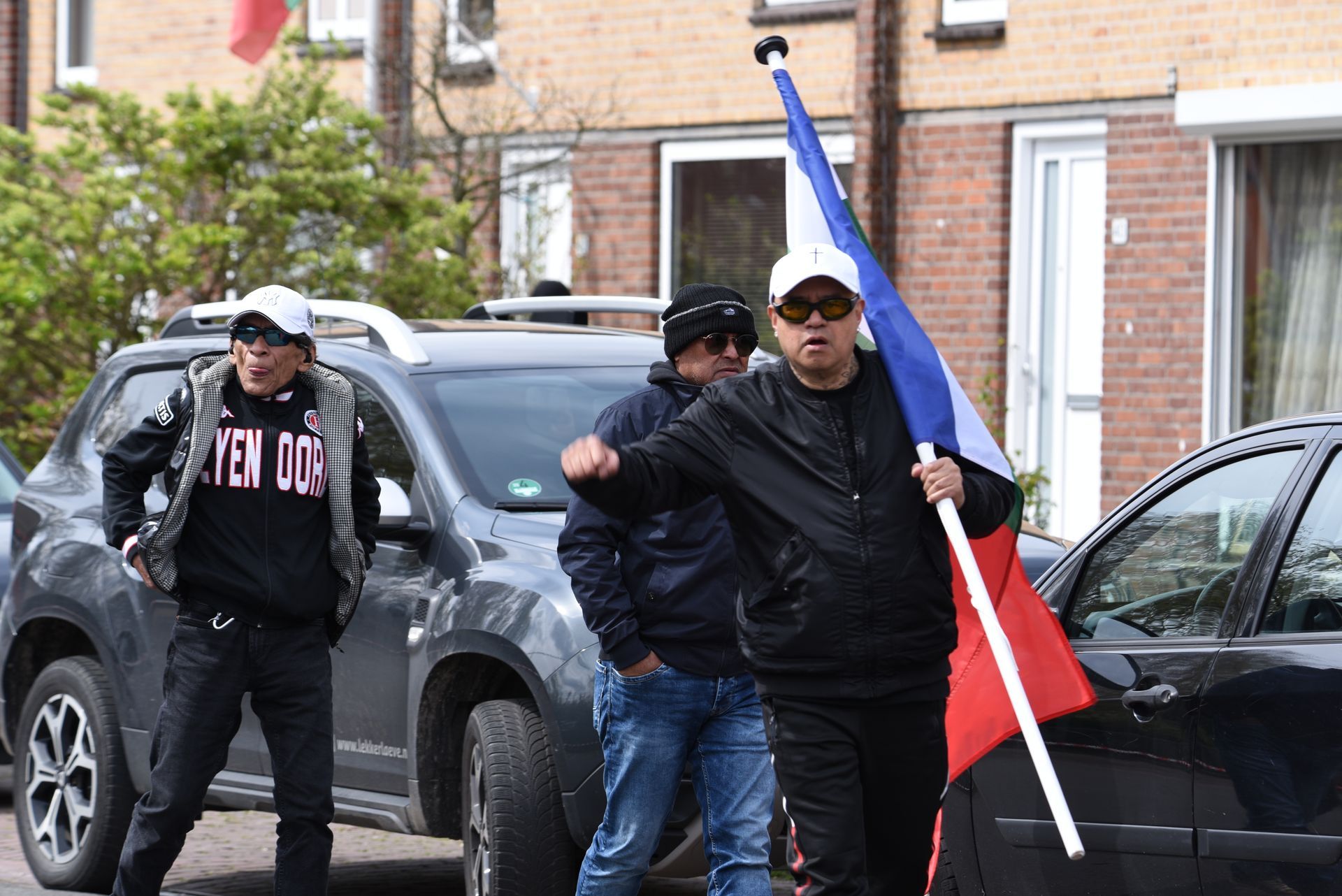 Een man houdt een vlag voor een auto vast.