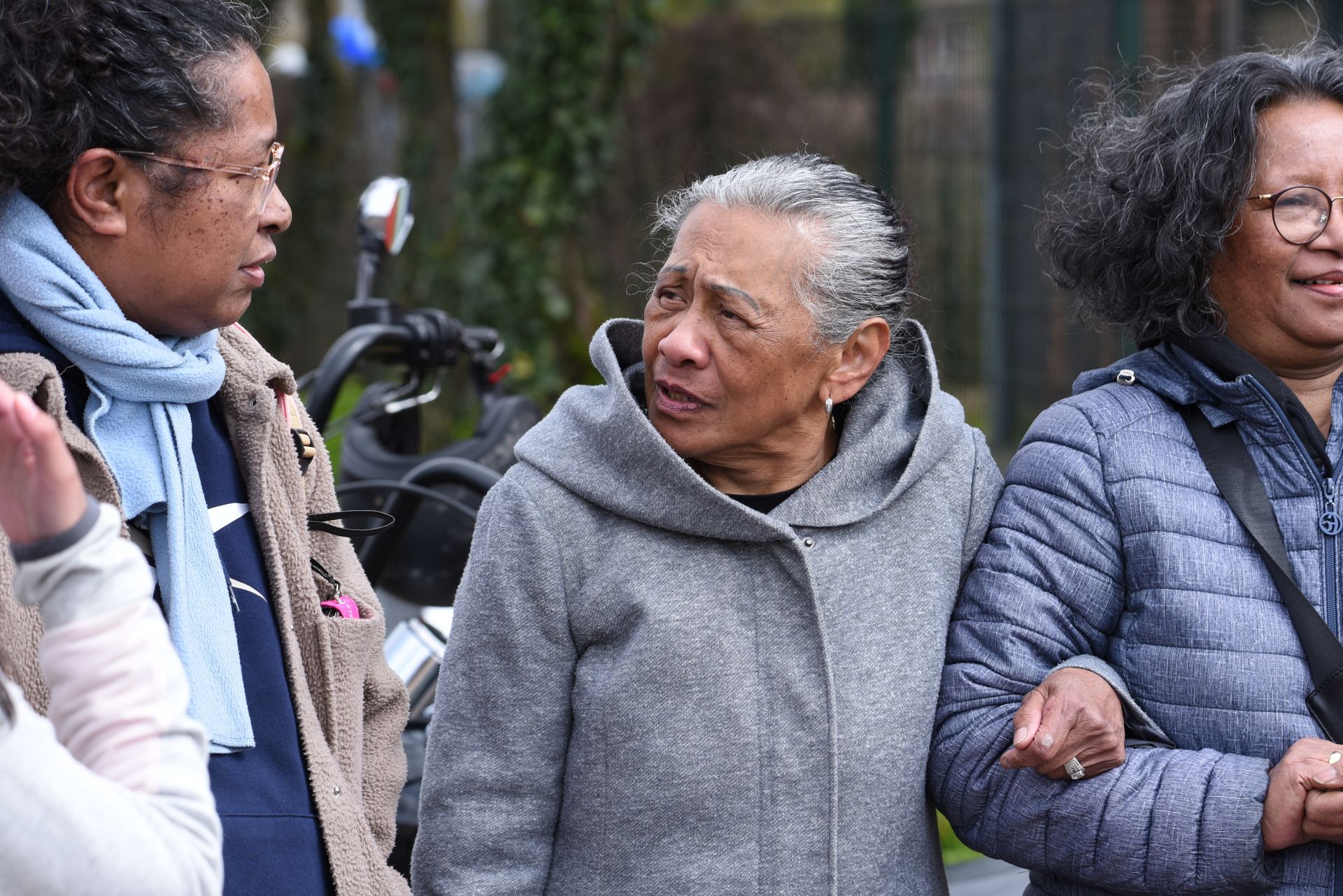Drie vrouwen staan ​​naast elkaar en praten.